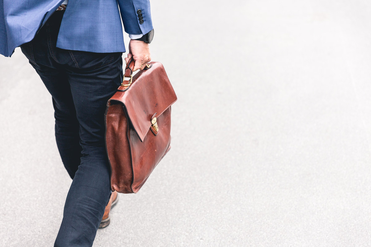 Individual walking with a laptop bag